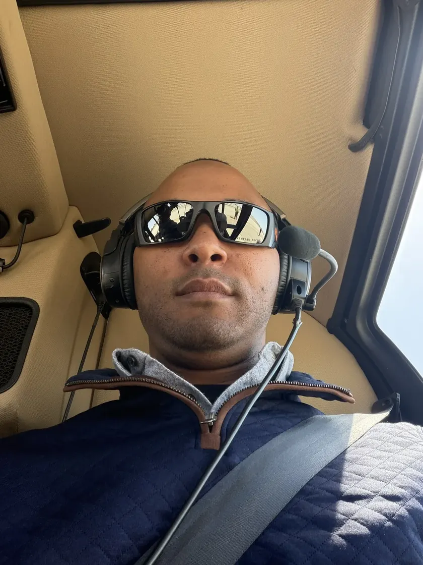 Kevin in a helicopter headset with aviator sunglasses